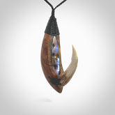 This picture shows a large matau, hook called a pā kahawai. It is carved from deer antler bone, wood, and paua shell. One only, free shipping worldwide. Provided with an adjustable black cord. Stunning work of Art to Wear by Fumio Noguchi.